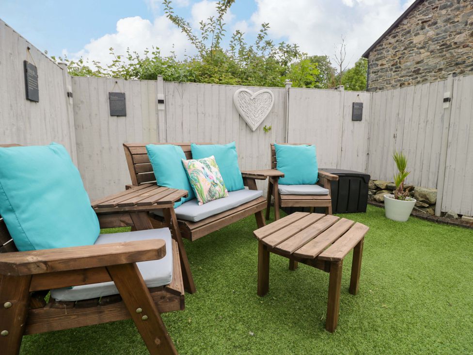 A garden with seating and table at Y Bwthyn in Llanbedr