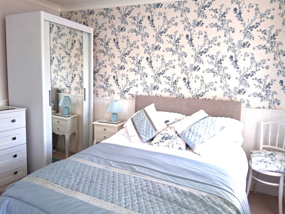 A bedroom with a bed and bedside table at Crooked Well in Timsbury, Nr Bath