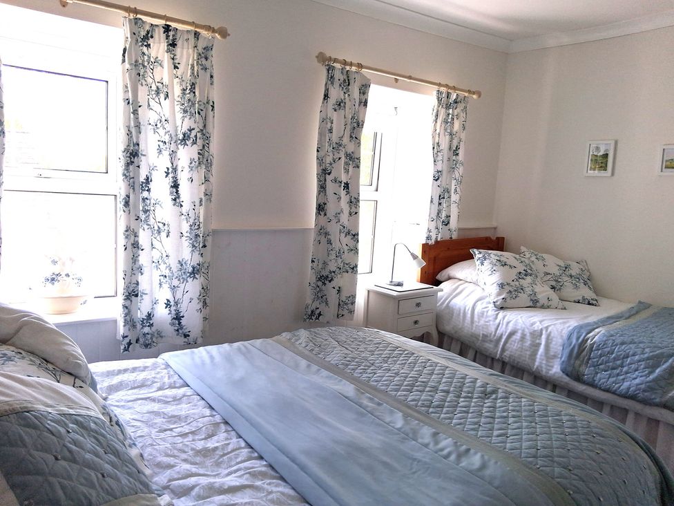 A bedroom with two beds and windows at Crooked Well in Timsbury, Nr Bath