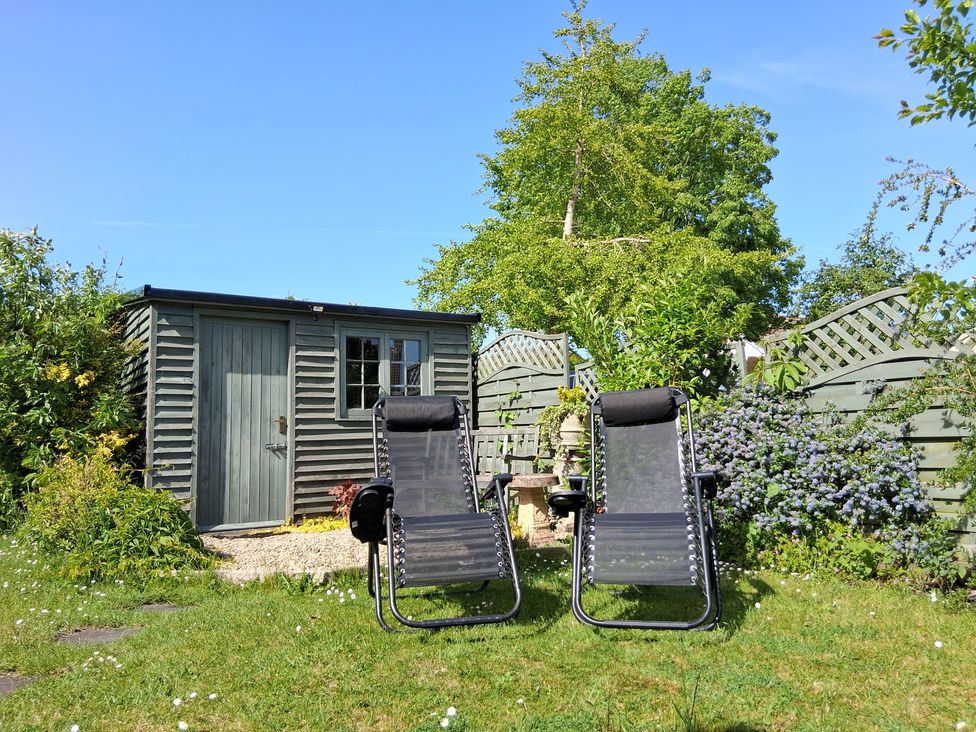 A garden with deck chairs and a shed at Crooked Well in Timsbury, Nr Bath