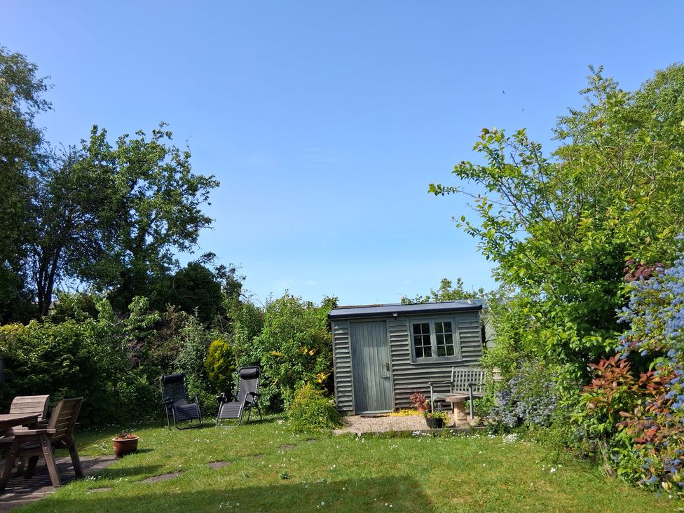 A garden with a shed and seating area at Crooked Well Timsbury, Nr Bath