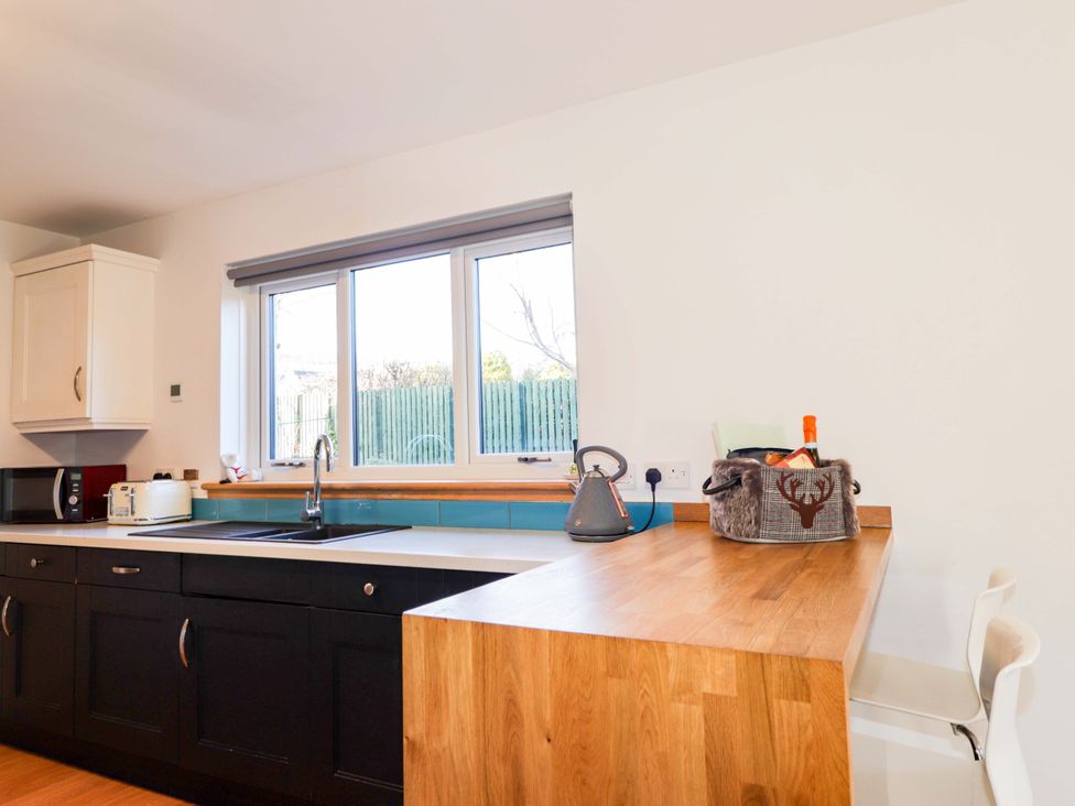 A kitchen with a sink and kitchen appliances at 3 Croftside Aviemore