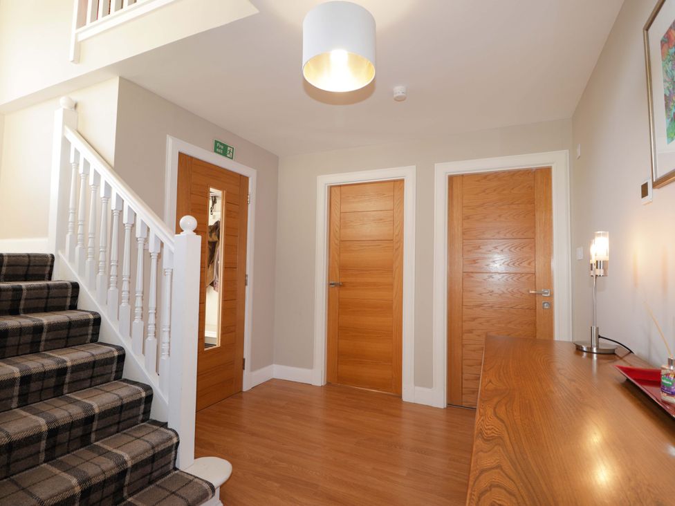 A hallway with a staircase and doors at 3 Croftside in Aviemore