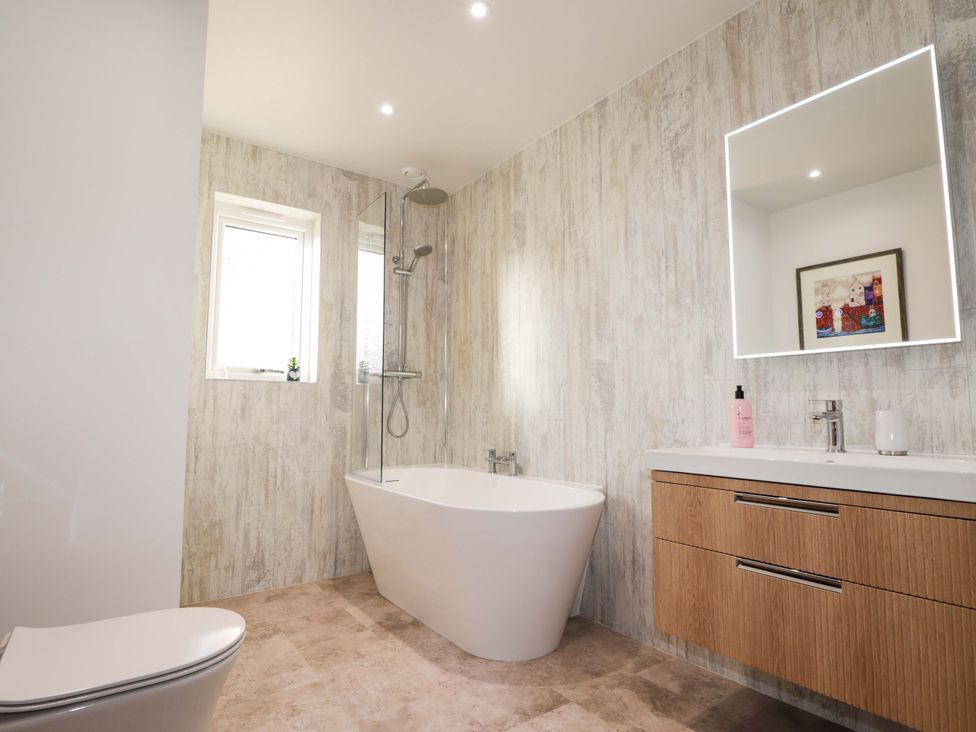 A bathroom with a bathtub and shower at 3 Croftside in Aviemore