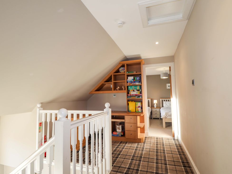 A hallway with a staircase and desk at 3 Croftside in Aviemore