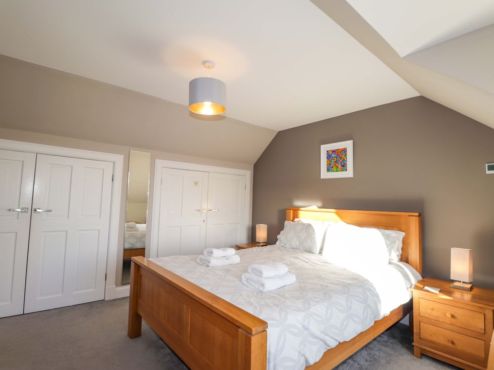 A bedroom with a bed and two wardrobes at 3 Croftside in Aviemore