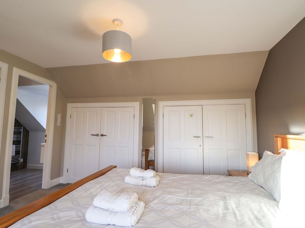 A bedroom with a bed and towels on the sheets at 3 Croftside in Aviemore