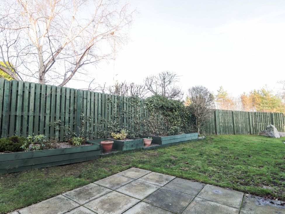 A garden with a fence and planters at 3 Croftside in Aviemore