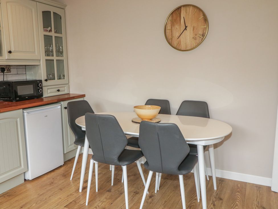 A dining room with a table and chairs at Hazel Cottage in Portrush