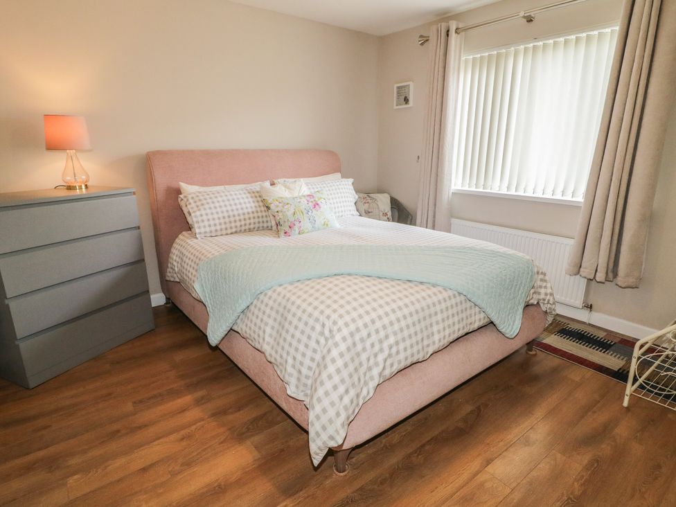 A bedroom with a bed and dresser at Hazel Cottage in Portrush