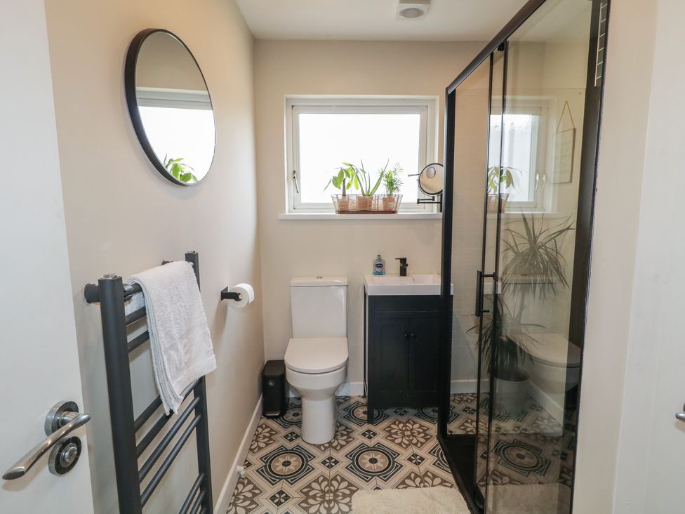 A bathroom with a shower, toilet, and sink at Hazel Cottage in Portrush