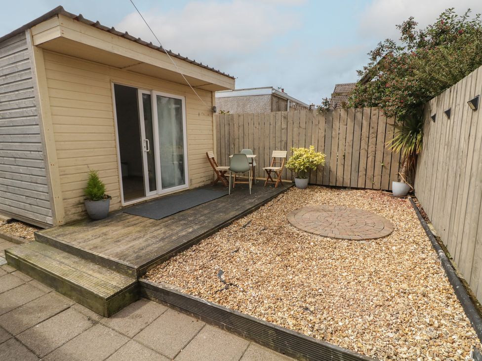 A wooden cabin with outdoor seating at Hazel Cottage in Portrush