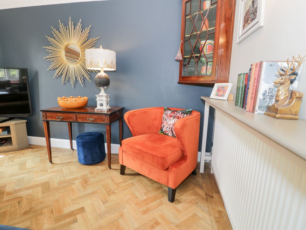 A living room with a side table and a television at Pengwern in Llanrwst
