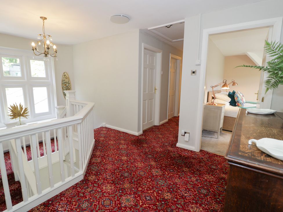 A hallway with a staircase and doorway to a room at Pengwern in Llanrwst