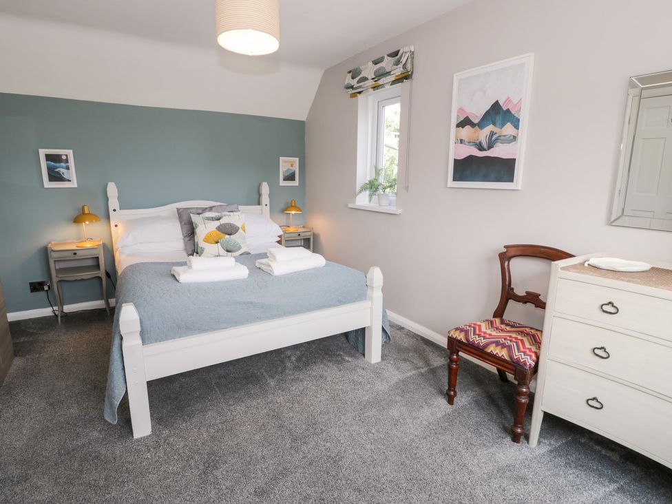 A bedroom with a bed and nightstand at Pengwern in Llanrwst