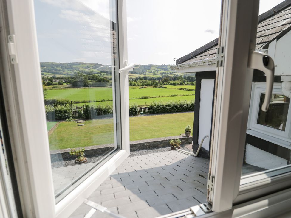 A view from a window overlooking a grassy area at Pengwern in Llanrwst