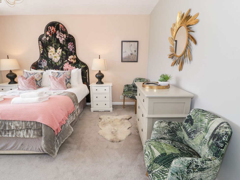 A bedroom with a bed and mirrors at Pengwern in Llanrwst