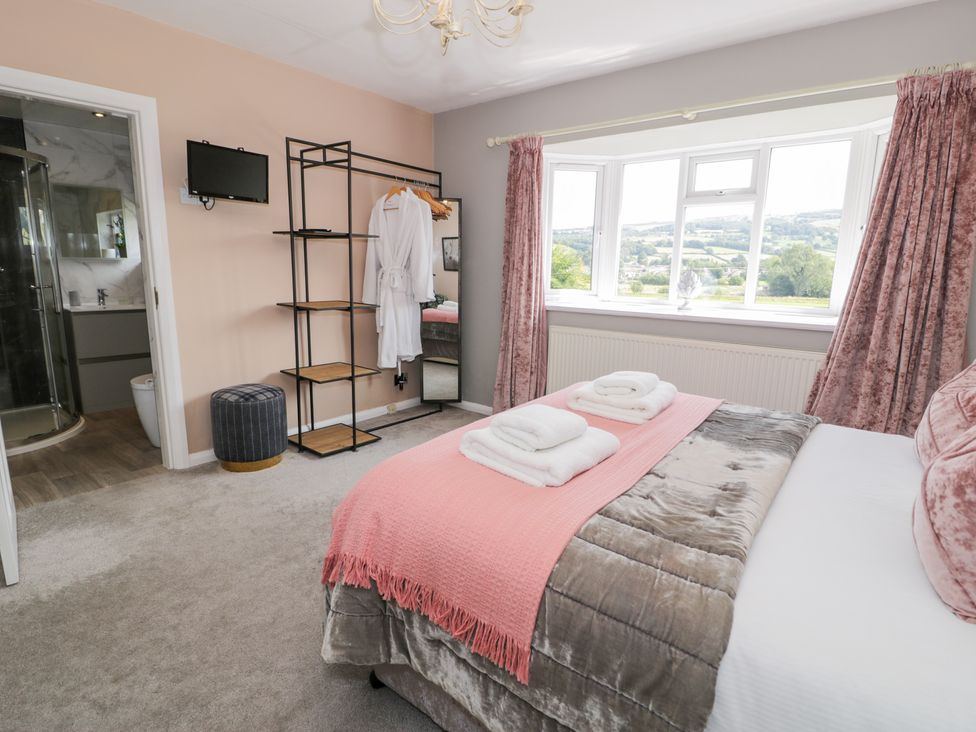 A bedroom with a bed and towels at Pengwern in Llanrwst