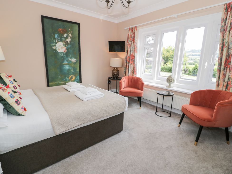 A bedroom with a bed and seating area at Pengwern in Llanrwst