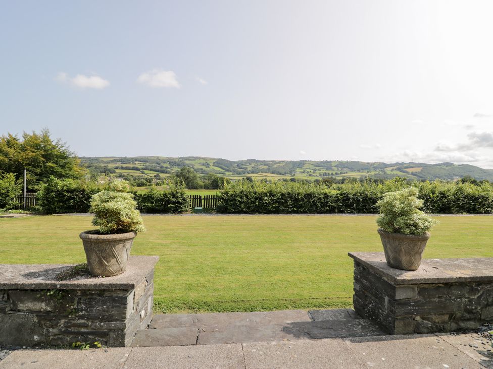 A garden view with planters and hills at Pengwern in Llanrwst