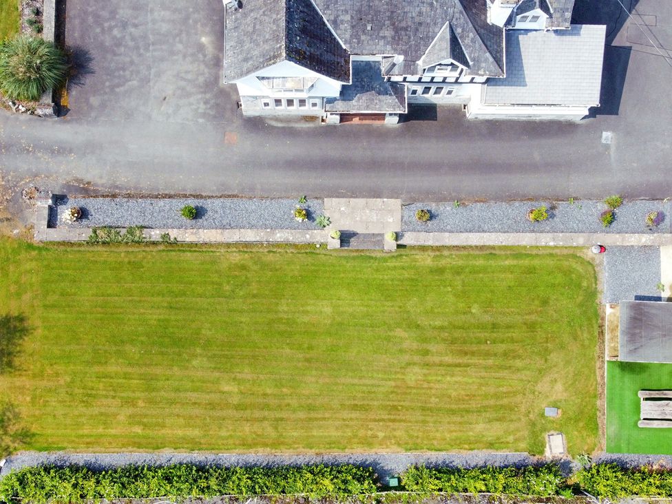 An outdoor view showing a lawn and house at Pengwern in Llanrwst