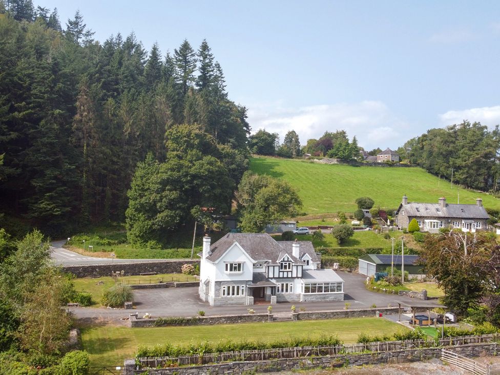 A house with garden and trees in the background at Pengwern Llanrwst
