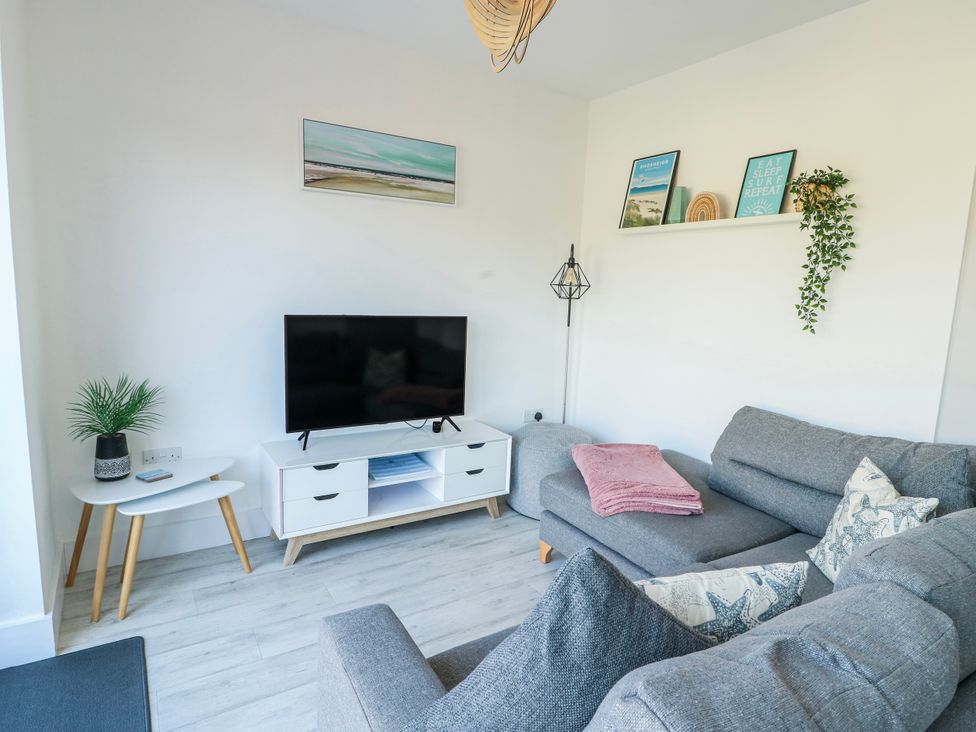 A living room with a television and couch at Dune Retreat in Llanfaelog near Rhosneigr
