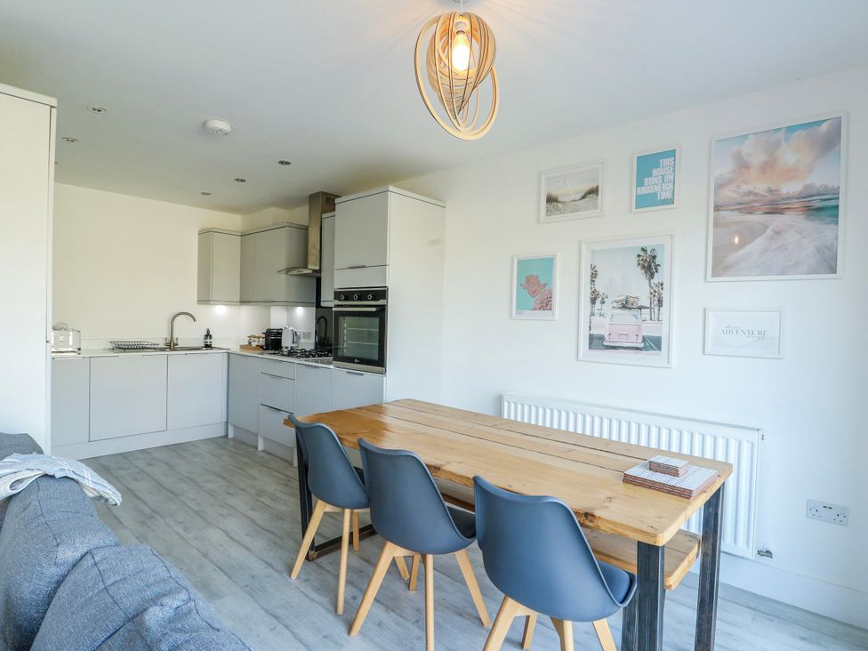 A kitchen with a dining table and chairs at Dune Retreat in Llanfaelog near Rhosneigr