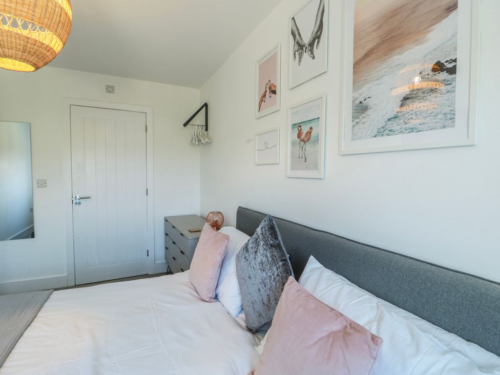 A bedroom with a bed and wall art at Dune Retreat Llanfaelog near Rhosneigr