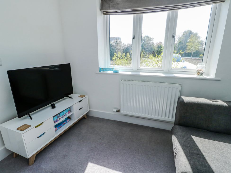 A living room with a television and sofa at Dune Retreat in Llanfaelog near Rhosneigr