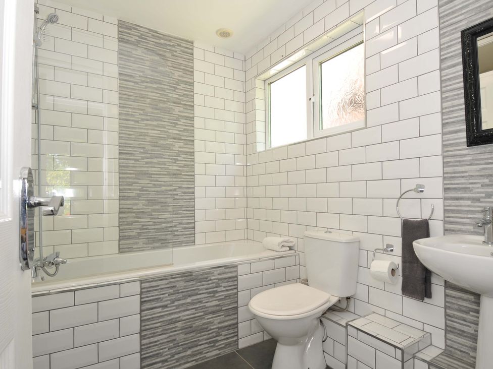 A bathroom with a bathtub shower toilet sink and window at 59 Valley Lodge Callington near Gunnislake