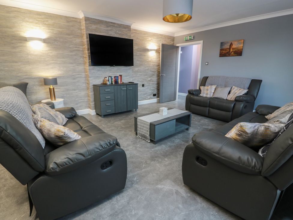 A living room with a sofa and television at Shotts Cottage Stirling