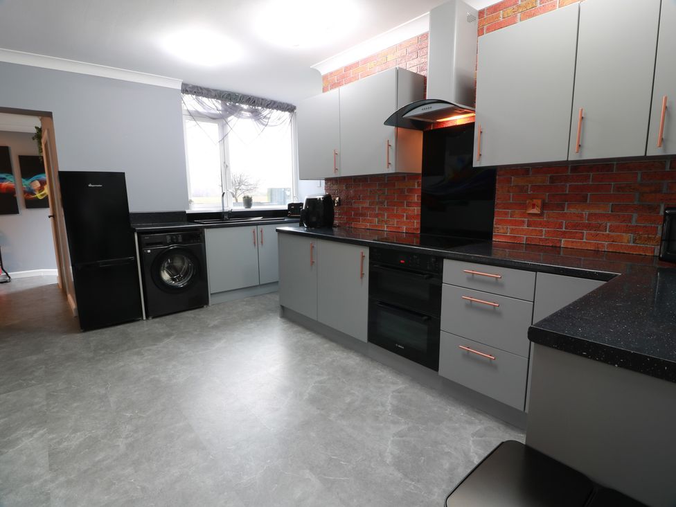 A kitchen with appliances and cabinets at Shotts Cottage in Stirling