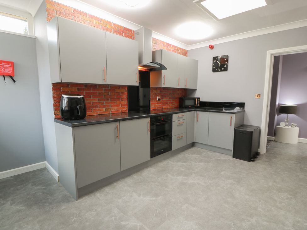 A kitchen with grey units and appliances at Shotts Cottage in Stirling