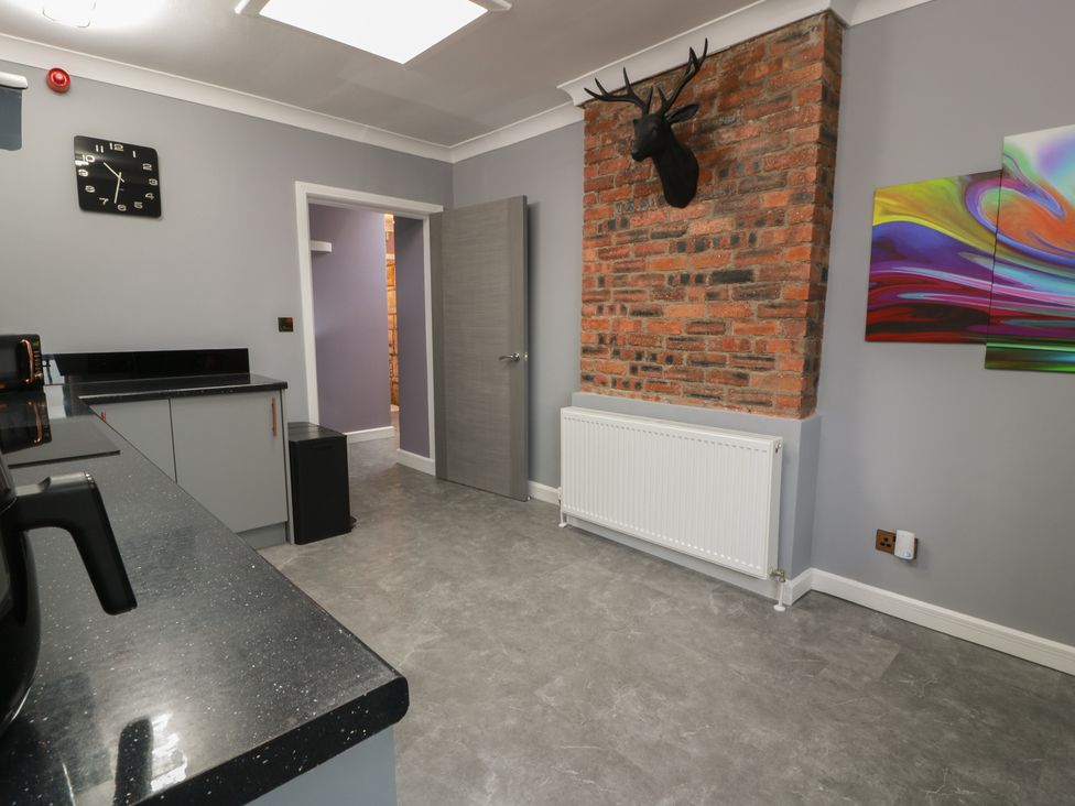 A kitchen with cabinets and a clock at Shotts Cottage in Stirling