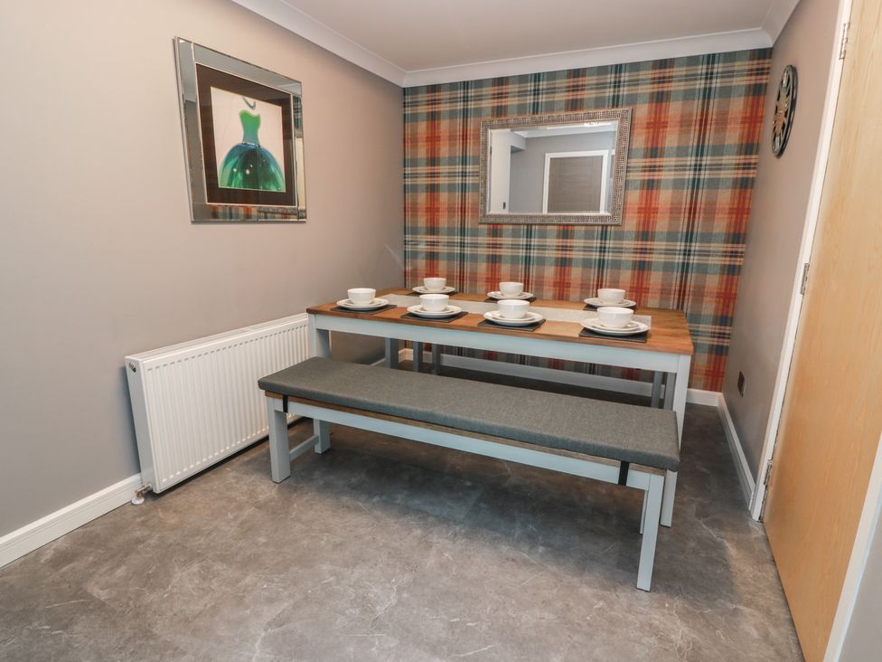 A dining room with a table set for meals at Shotts Cottage in Stirling
