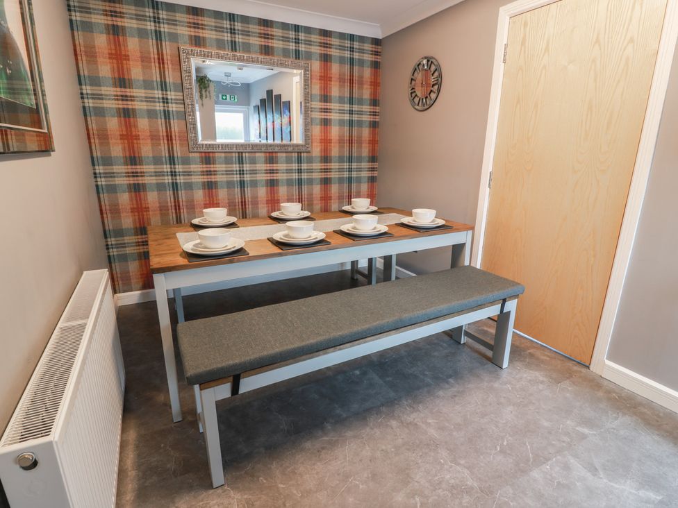 A dining room with a table set for meals at Shotts Cottage in Stirling