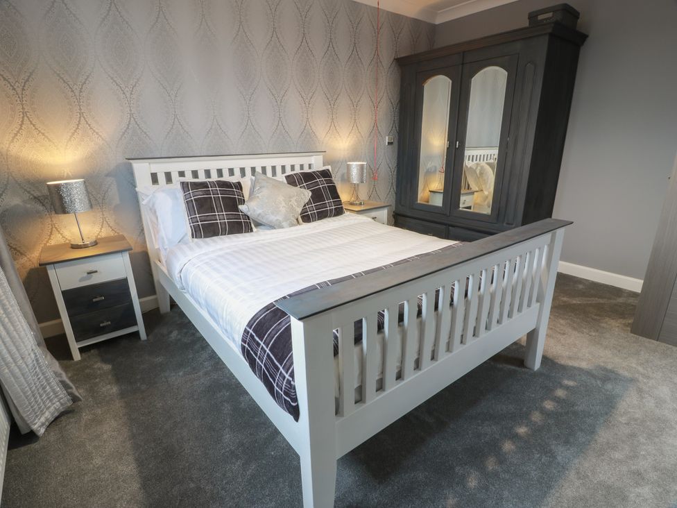A bedroom with a bed and furniture at Shotts Cottage in Stirling
