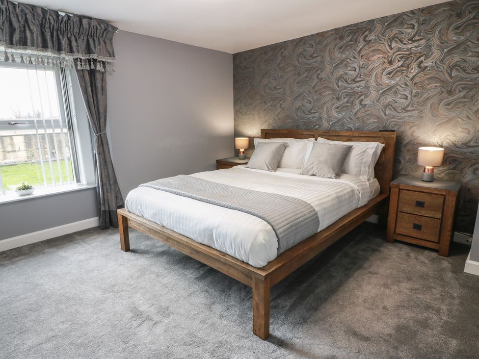A bedroom with a bed and bedside tables at Shotts Cottage Stirling