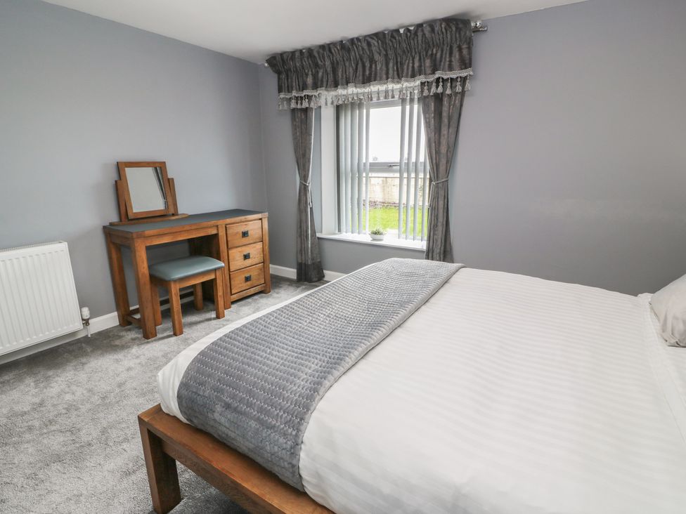 A bedroom with a bed, desk and window at Shotts Cottage in Stirling