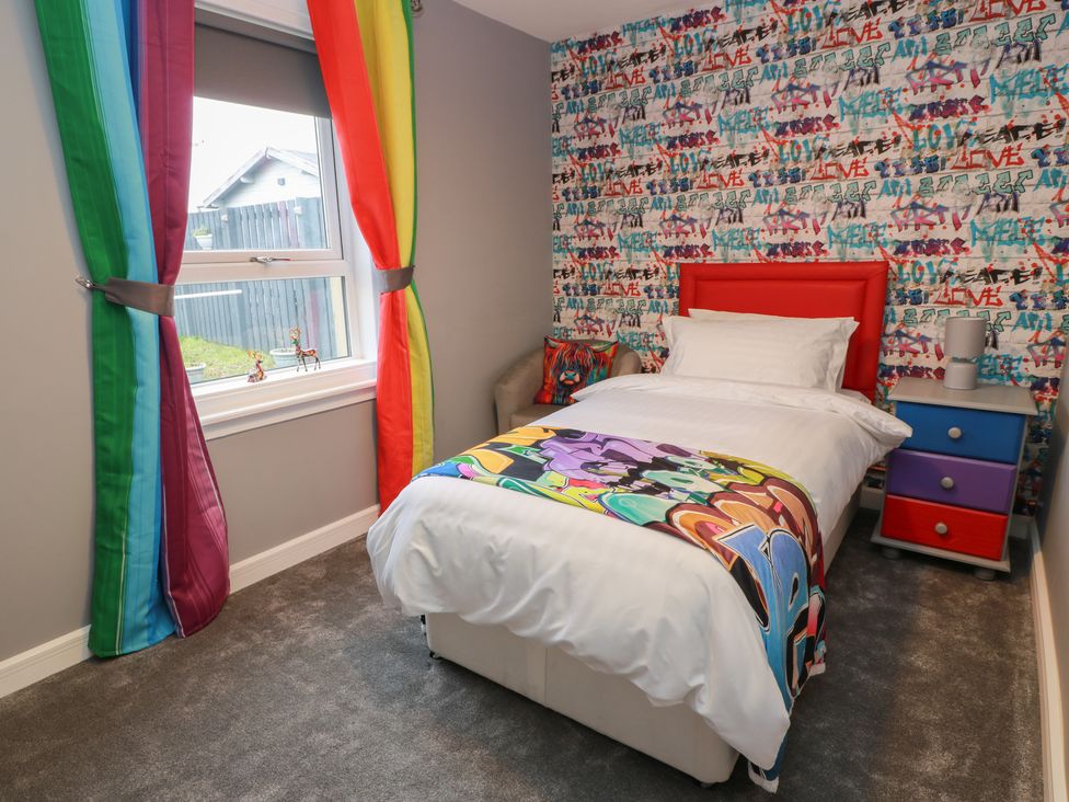 A bedroom with a bed and colorful decor at Shotts Cottage in Stirling
