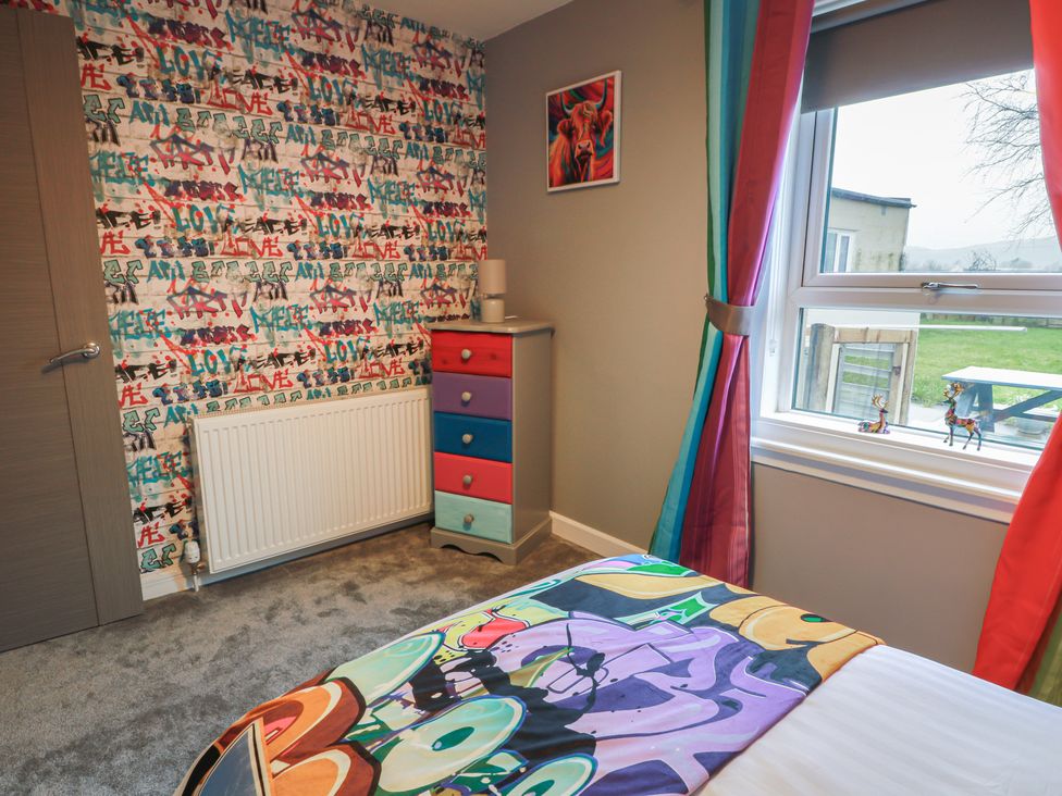 A bedroom with a bed and colorful drawer at Shotts Cottage Stirling