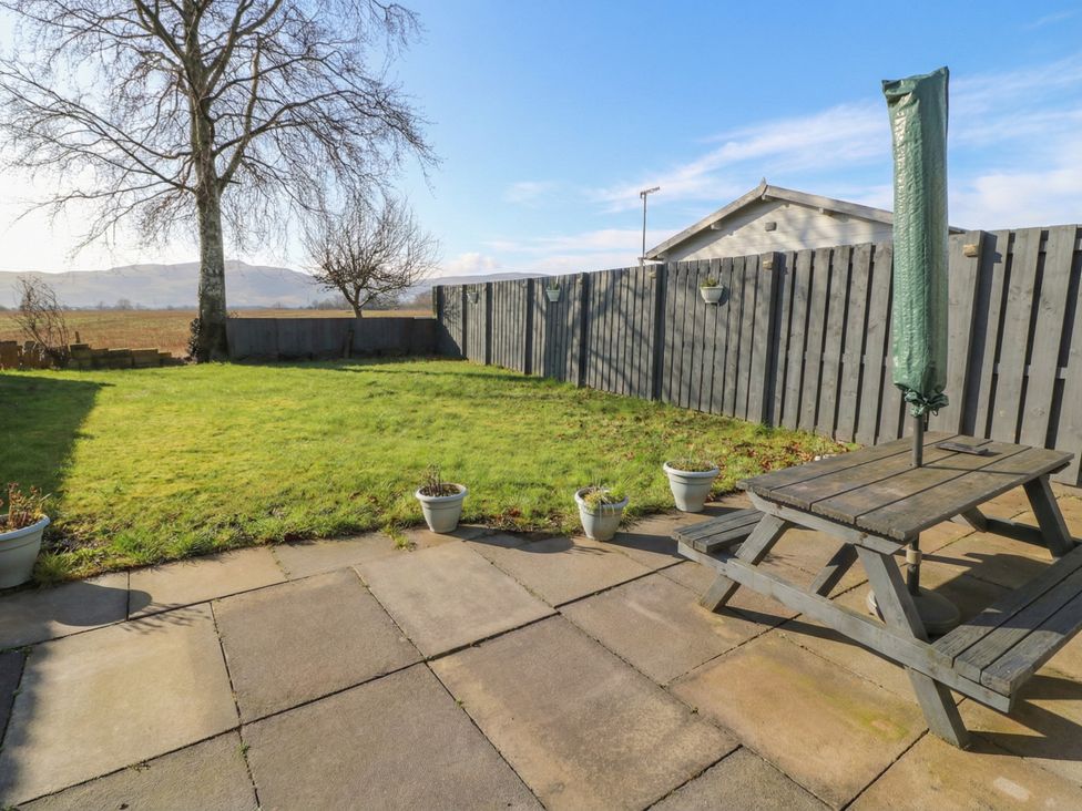 A garden with a table and planters at Shotts Cottage Stirling