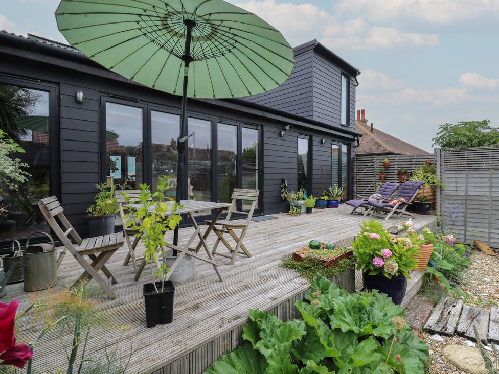 A garden area with wooden decking and table with chairs at The Artists House by The Sea Herne Bay