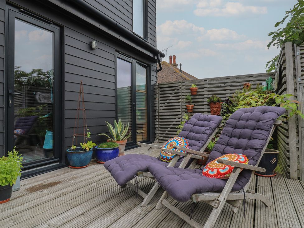 An outdoor patio with reclining chairs and flower pots at The Artists House by The Sea, Herne Bay