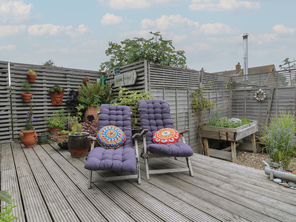 A garden with lounge chairs and flower pots at The Artists House by The Sea Herne Bay
