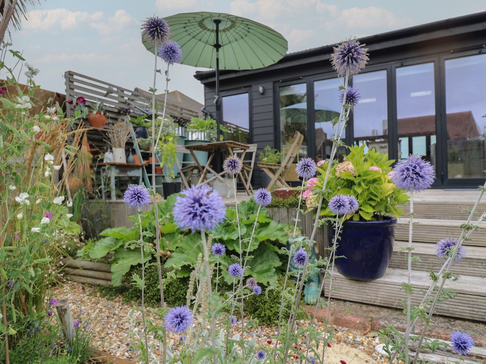 A garden with flowers and a seating area at The Artists House by The Sea in Herne Bay
