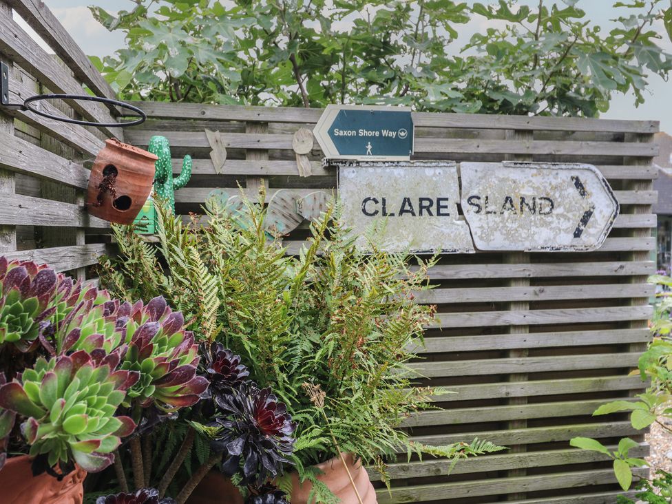 A wooden fence with signs and potted plants in a garden at The Artists House by The Sea Herne Bay