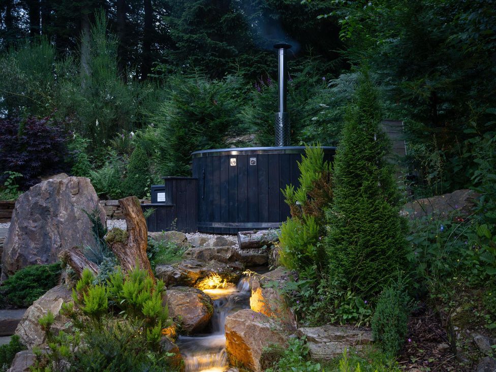 A hot tub with a chimney in a garden at Heilan Roo near Killiecrankie and Pitlochry and Blair Atholl