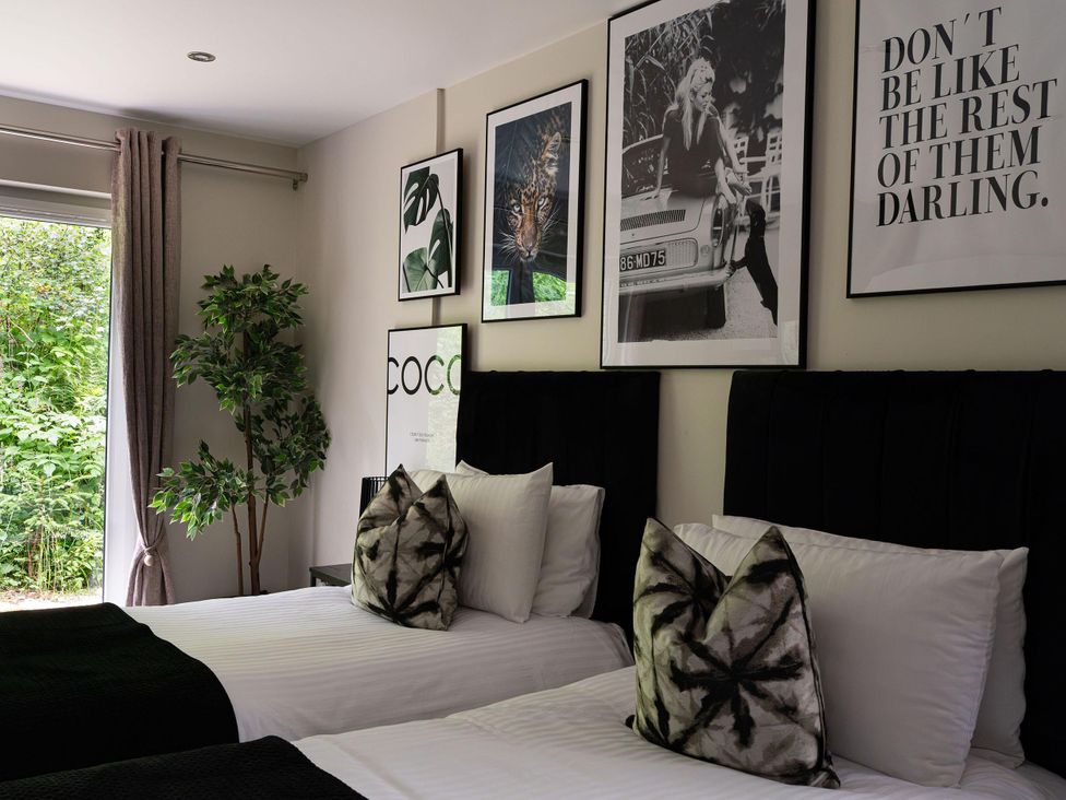 A bedroom with two beds and various wall art at Heilan Roo in Killiecrankie near Pitlochry and Blair Atholl